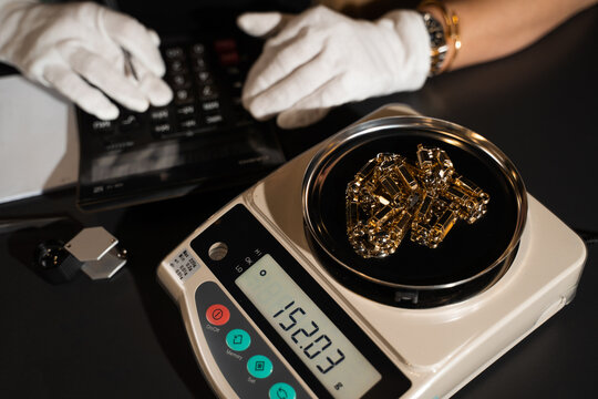 Jeweler weighs rings on a precision scale to determine their exact value.