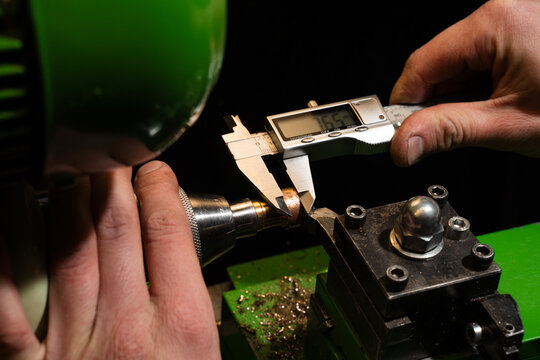 Ring sizing is performed with a professional measuring tool in a jewelry workshop.