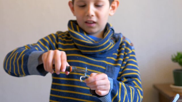Child's Hands Using Pliers to Bend Metal Wire Indoors | Young Maker at Work, Hands-On Learning and the Joy of Building Things Yourself