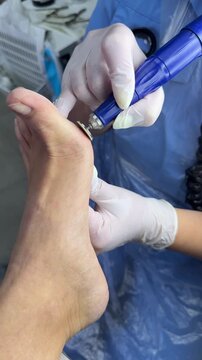 Foot treatment. Pedicure master makes hardware pedicure