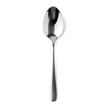 A reflective silver tablespoon standing upright on white.