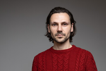 Fototapeta premium Friendly confident man with beard in red sweater professional portrait