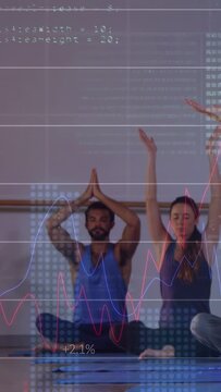 Vertical video: Group following guide raising palms into prayer while graphs rising in yoga studio