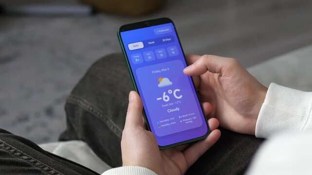Stay prepared for the cold. User monitoring freezing temperatures and heavy snow alerts on a smart phone. High-res footage for seasonal marketing, climate reports, and mobile software demos.