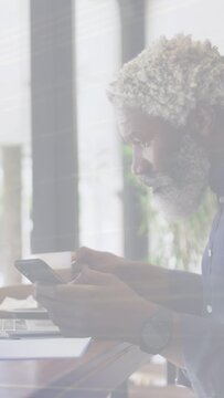 Vertical video: Businessman glancing at smartphone, lowering mug, tapping, typing business emails