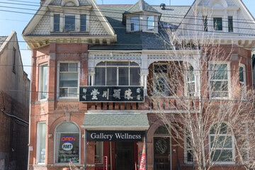 Fototapeta premium historic house facade and sign of Gallery Wellness located at 346 Dundas St W, Toronto