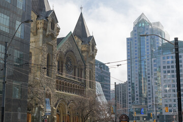 Obraz premium looking southwest on King St W near Simcoe St to historic St. Andrew's Presbyterian Church and modern office buildings, Toronto