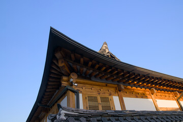 Fototapeta premium Close-up of traditional Korean Hanok roof and eaves under blue sky