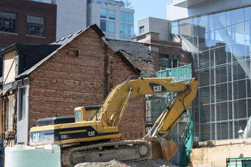 Naklejka premium heavy equipment (CAT) excavator at a demolition site near Jack Cooper Lane, Peter St, and Queen St W, Toronto