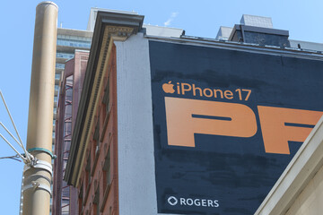 Fototapeta premium mural advertising for cell phone on exterior wall of the historic Warwick Bros. & Rutter Ltd building 401-409 King St W at Spadina Av, Toronto