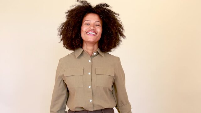 Joyful african american woman with afro hair making a heart symbol with her hands and smiling looking at the camera