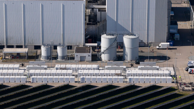 Lelystad, Netherlands - 21 April 2026: Aerial view of the Maxima plant power station and offshore wind turbines along the coast under a clear blue sky.