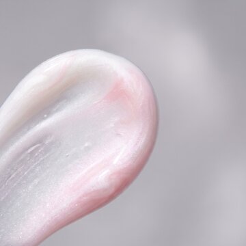 Macro pearlized white and soft pastel pink cosmetic fluid smear