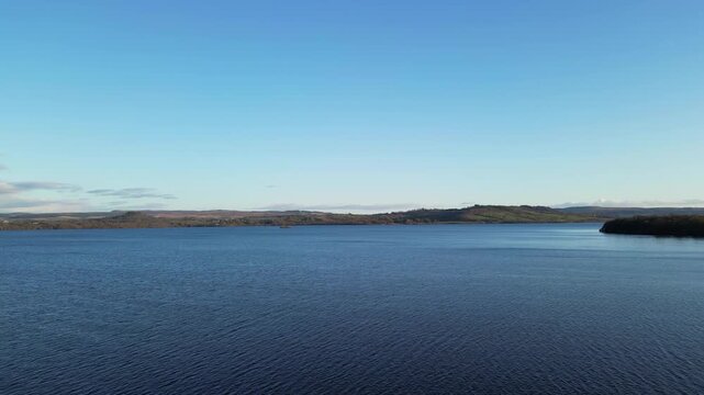 Aerial View of Calm Water of Massive Lake at Balmaha Valley Village Near Glasgow Landscape During Sunset. Village is a popular tourist destination for picnickers and day trippers from Glasgow