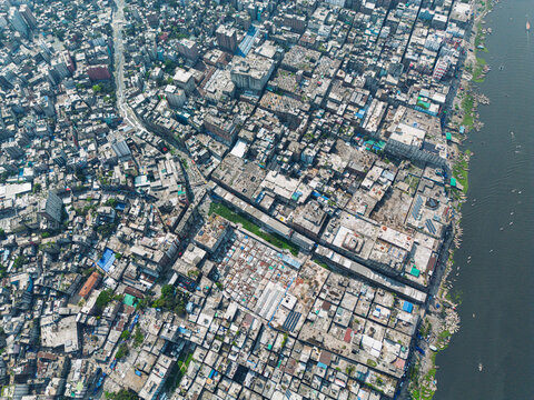 Dhaka, Bangladesh - 11 April 2026: Aerial view of the Buriganga River flowing past the densely packed urban rooftops and crowded residential buildings in the old part of the city.