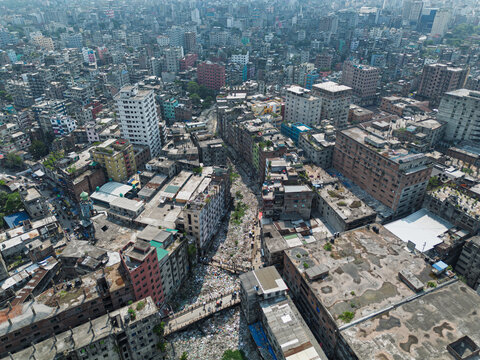Dhaka, Bangladesh - 11 April 2026: Aerial view of the Buriganga River filled with plastic waste and pollution, surrounded by the dense urban architecture and crowded buildings of the city.