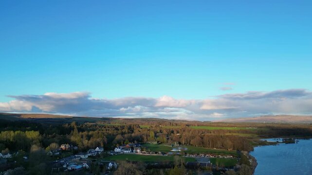 Aerial View of Calm Water of Massive Lake at Balmaha Valley Village Near Glasgow Landscape During Sunset. Village is a popular tourist destination for picnickers and day trippers from Glasgow