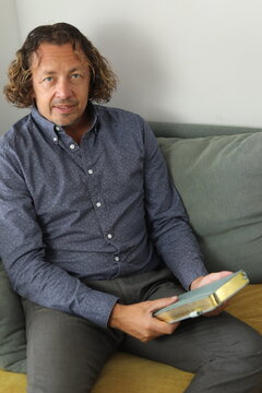 Man Reading Book on Sofa