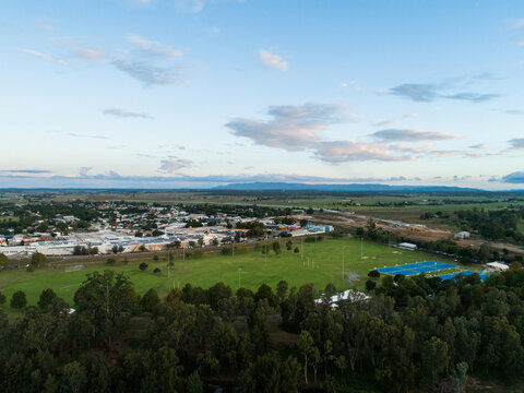 Netball courts on sports field in Singleton at dusk with shopping district of town behind
