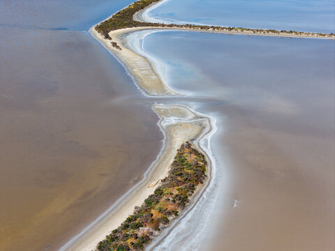 Aerial view of levee banks and crusty shorelines around manmade salt ponds