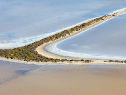 Aerial view of levee banks and crusty shorelines around manmade salt ponds