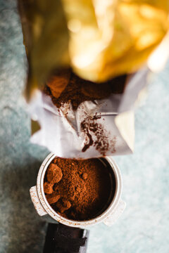 Pouring fresh ground coffee from a bag into an espresso portafilter