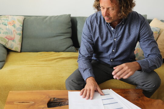 Man Reviewing Documents on Sofa