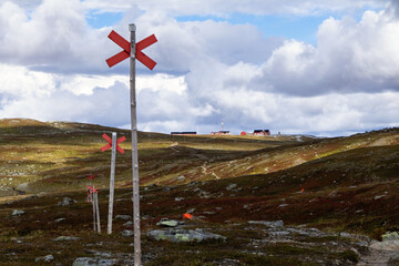 Fototapeta premium Swedish hiking trail signs and Blåhammaren mountain station on the horizon.
