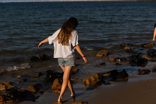 girl walking on the shoreline in late afternoon light