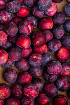 Full fruit box of fresh organic plums from overhead