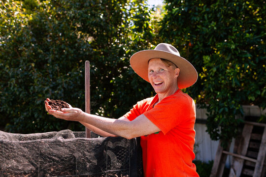 environmentalist composting advocate woman holding dirt made in garden compost system