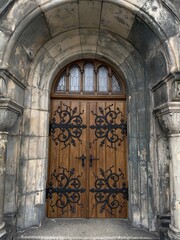 Obraz premium Old Church wooden arched door on a medieval style building enterance