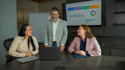 Business professionals collaborating in data analysis during a meeting with a presentation. © Daniel Caro