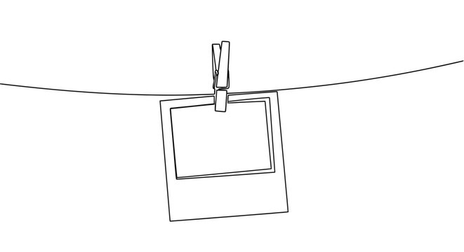 A single empty instant photo frame hanging on a string with a clothespin.