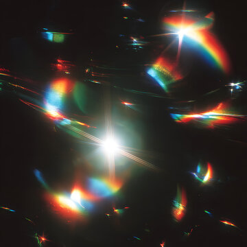 Abstract light effects with rainbow flares and bokeh on dark background.