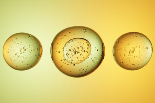 Golden spheres with bubbles, gradient background, 3D render