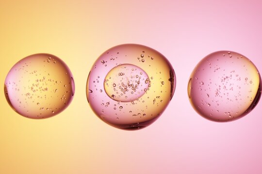 Oil droplets in water, pink orange background, macro texture