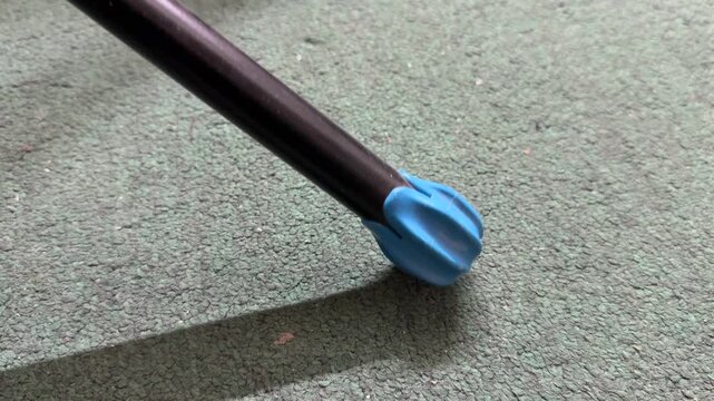 Rubber tip of walking cane touching floor surface, mobility aid equipment for walking support