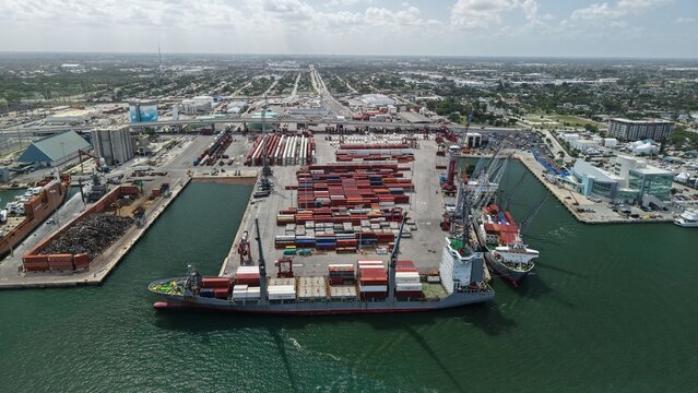 Riviera Beach, United States - 15 April 2026: Aerial view of the Port of Palm Beach with cargo ships, shipping containers, and industrial cranes along the waterfront.
