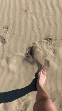 Piedi con smalto rosa sulla sabbia