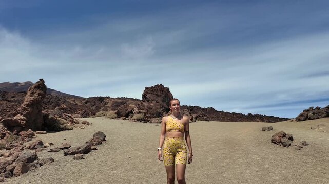Fit woman walking in a volcanic desert landscape