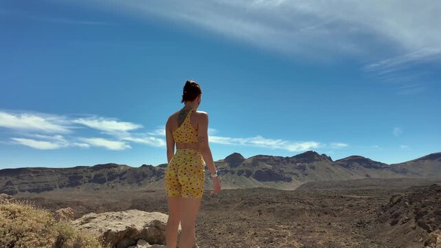Young woman stretching arms in volcanic landscape