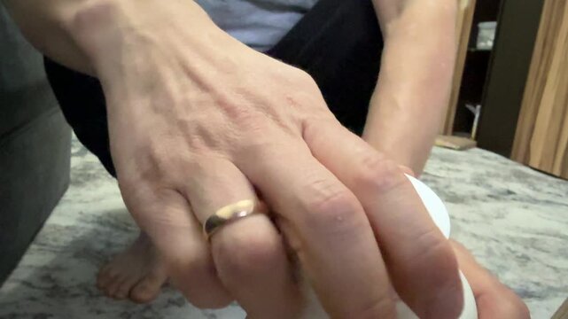 Close-up of hands opening a white plastic jar