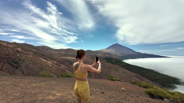Influencer girl taking selfie on a volcano mountain top