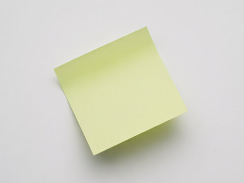 Blank light yellow sticky note for reminder messages and office stationery, isolated on white background