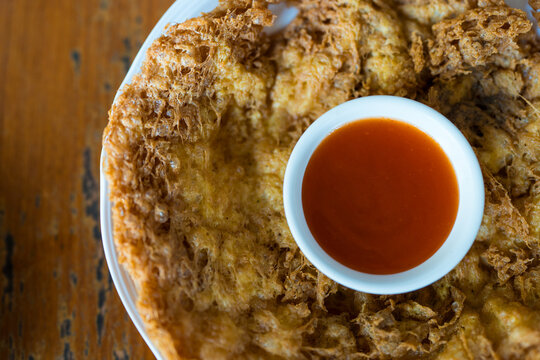 Khai Jeow Moo Sab. Thai Minced Pork Omelette. A crispy-edged, fluffy omelette filled with savory minced pork and a bowl of chili sauce on the center