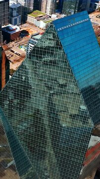Footage over the tops of Fountain Place and AMLI Fountain Place buildings. Sun reflecting from the top of a tower. Downtown of Dallas, Texas, USA. Vertical video