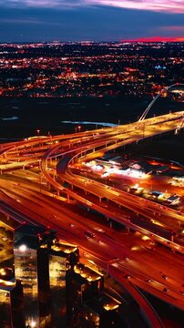 Reunion Tower of Dallas with blue lights on at top. Well-illuminated roads and splendid city scenery at backdrop. Aerial view. Vertical video