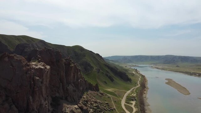 Aerial 4K view of Ili River and sacred Tamgaly Tas petroglyphs in Kazakhstan steppe
