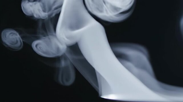 A mysterious white object emits smoke against a dark background, evoking a sense of intrigue and curiosity.